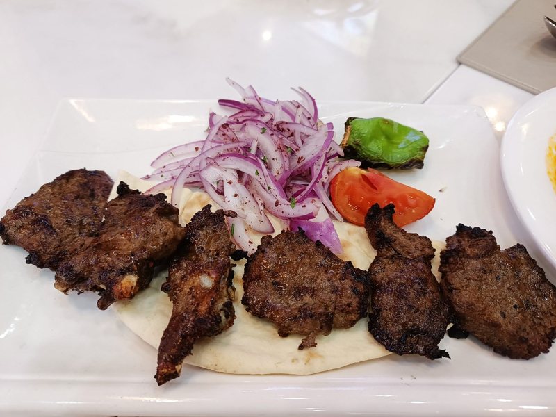 Grilled meat kebabs with onions